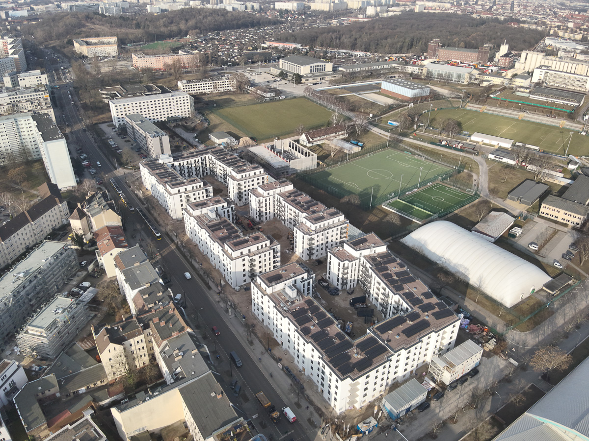 Neubau-Wohnquartiers mit installierter Photovoltaikanlage auf den Flachdächern der Mehrfamilienhäuser. Das Projekt zeigt die professionelle Umsetzung einer großflächigen PV-Anlage zur nachhaltigen Stromerzeugung im urbanen Wohnungsbau. Die Solarmodule wurden auf mehreren Gebäuden montiert und tragen zur CO₂-Reduzierung sowie zur Energieeffizienz moderner Wohnanlagen bei.