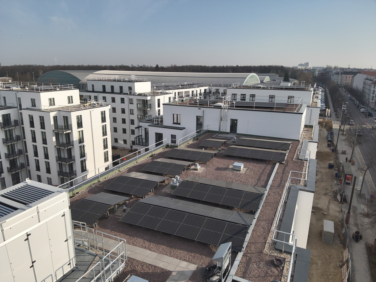 Neubau-Wohnquartiers mit installierter Photovoltaikanlage auf den Flachdächern der Mehrfamilienhäuser. Das Projekt zeigt die professionelle Umsetzung einer großflächigen PV-Anlage zur nachhaltigen Stromerzeugung im urbanen Wohnungsbau. Die Solarmodule wurden auf mehreren Gebäuden montiert und tragen zur CO₂-Reduzierung sowie zur Energieeffizienz moderner Wohnanlagen bei.