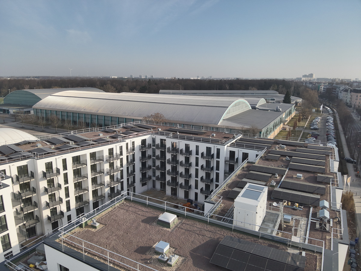 Neubau-Wohnquartiers mit installierter Photovoltaikanlage auf den Flachdächern der Mehrfamilienhäuser. Das Projekt zeigt die professionelle Umsetzung einer großflächigen PV-Anlage zur nachhaltigen Stromerzeugung im urbanen Wohnungsbau. Die Solarmodule wurden auf mehreren Gebäuden montiert und tragen zur CO₂-Reduzierung sowie zur Energieeffizienz moderner Wohnanlagen bei.