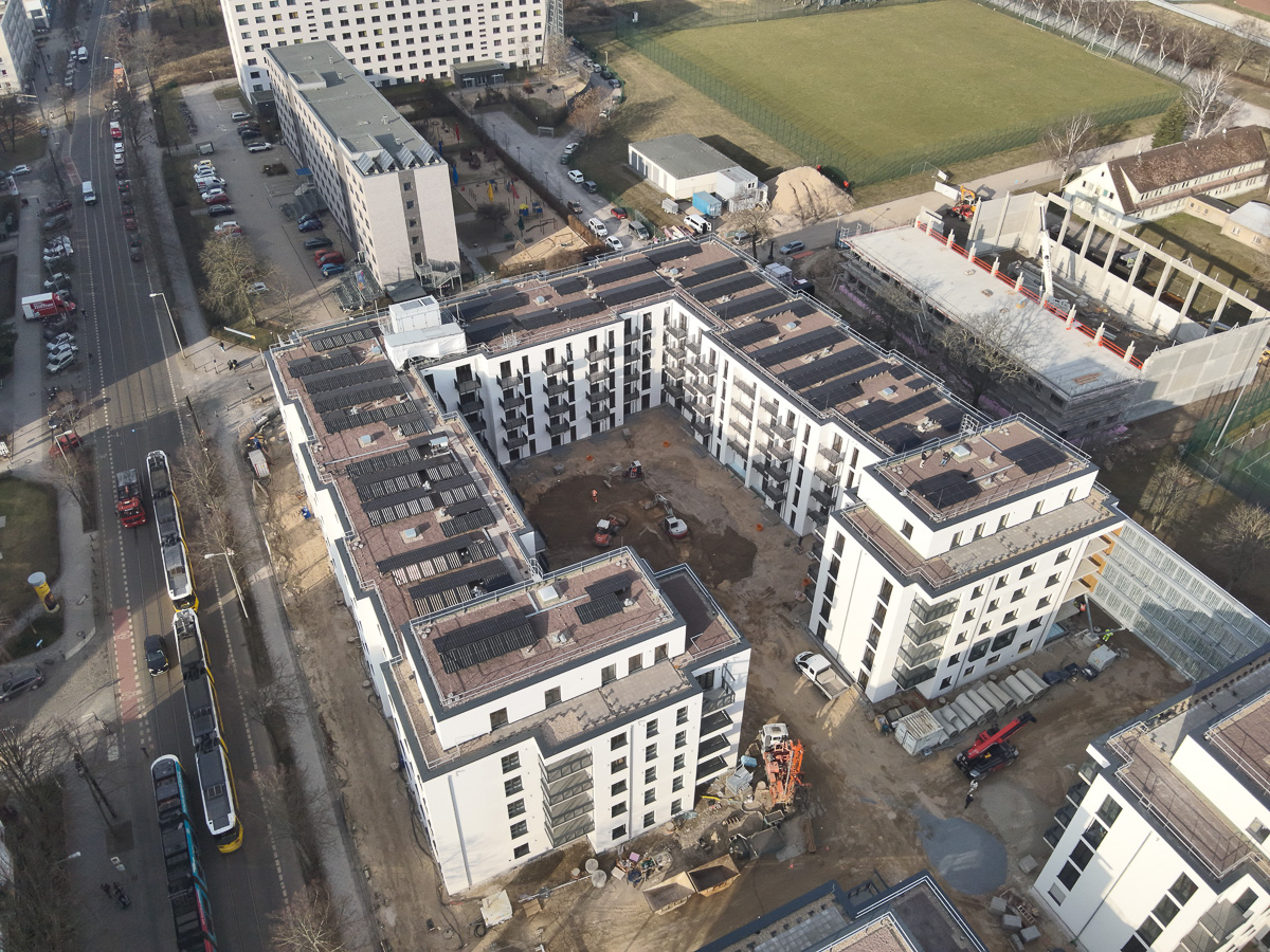 Neubau-Wohnquartiers mit installierter Photovoltaikanlage auf den Flachdächern der Mehrfamilienhäuser. Das Projekt zeigt die professionelle Umsetzung einer großflächigen PV-Anlage zur nachhaltigen Stromerzeugung im urbanen Wohnungsbau. Die Solarmodule wurden auf mehreren Gebäuden montiert und tragen zur CO₂-Reduzierung sowie zur Energieeffizienz moderner Wohnanlagen bei.