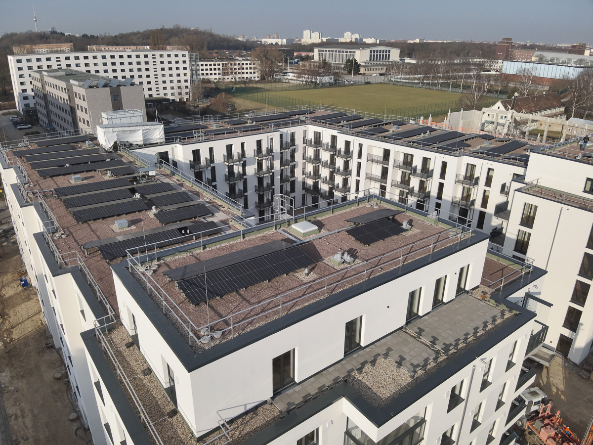Neubau-Wohnquartiers mit installierter Photovoltaikanlage auf den Flachdächern der Mehrfamilienhäuser. Das Projekt zeigt die professionelle Umsetzung einer großflächigen PV-Anlage zur nachhaltigen Stromerzeugung im urbanen Wohnungsbau. Die Solarmodule wurden auf mehreren Gebäuden montiert und tragen zur CO₂-Reduzierung sowie zur Energieeffizienz moderner Wohnanlagen bei.