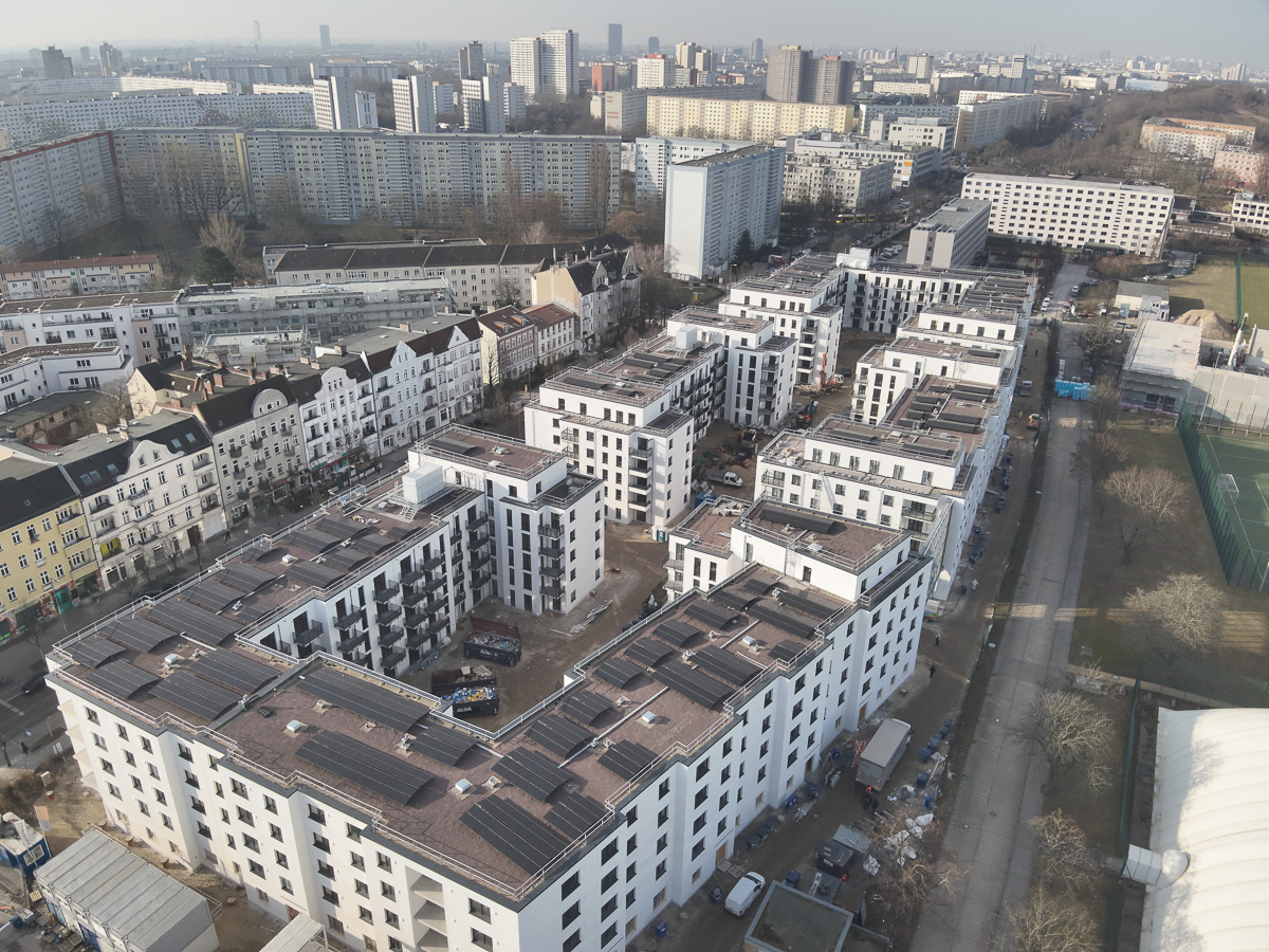 Neubau-Wohnquartiers mit installierter Photovoltaikanlage auf den Flachdächern der Mehrfamilienhäuser. Das Projekt zeigt die professionelle Umsetzung einer großflächigen PV-Anlage zur nachhaltigen Stromerzeugung im urbanen Wohnungsbau. Die Solarmodule wurden auf mehreren Gebäuden montiert und tragen zur CO₂-Reduzierung sowie zur Energieeffizienz moderner Wohnanlagen bei.